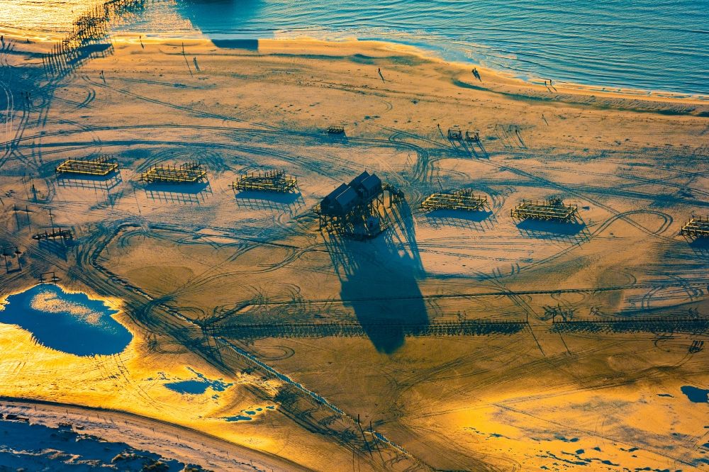 Aerial image Sankt Peter-Ording - Sandy beach landscape on the North Sea coast Pile dwellings restaurants - restaurants in Sankt Peter-Ording in the afterglow with long shadows in Schleswig-Holstein