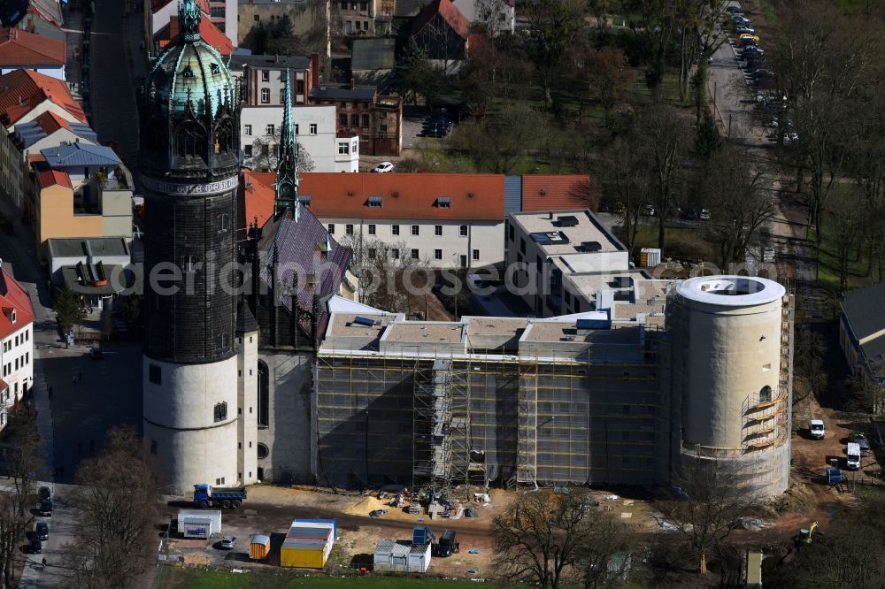 Aerial image Lutherstadt Wittenberg - Castle church of Wittenberg. The castle with its 88 m high Gothic tower at the west end of the town is a UNESCO World Heritage Site. It gained fame as the Wittenberg Augustinian monk and theology professor Martin Luther spread his disputation