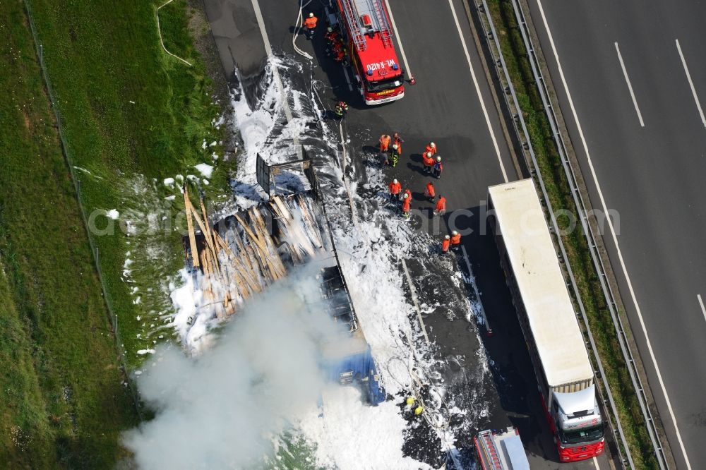 Hollenstedt from the bird's eye view: Foam carpet-fighting operations of a fire department in a truck-fire-fire on the motorway Autobahn A1 - E22 at Hollenstedt in the state of Lower Saxony