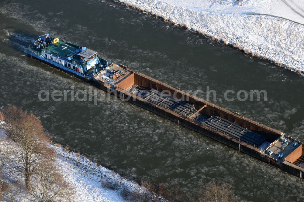 Parey from the bird's eye view: Ship and pushed convoys of inland waterway transport in driving on the winter covered with snow and ice flux flow of the waterway of the Elbe-Havel Canal in Parey in the state of Saxony-Anhalt