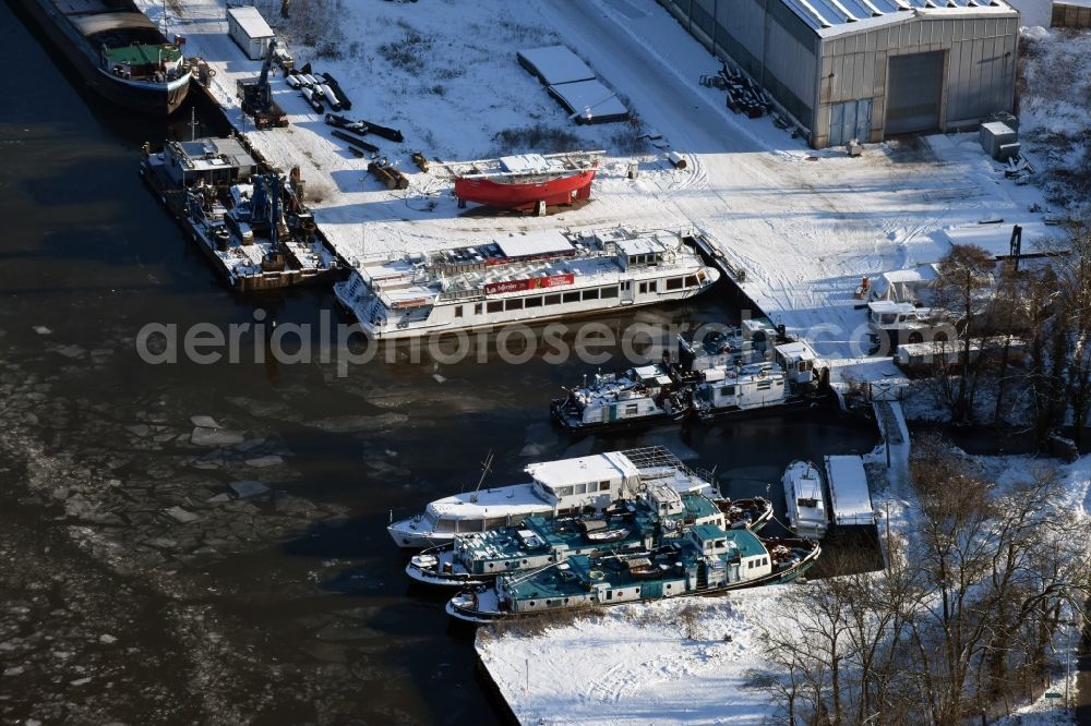 Aerial photograph Genthin - Ships and boats on wintry and ice-covered Elbe-Havel-Canal in Genthin in the state of Saxony-Anhalt. The snow-covered ships area located at a dock amidst ice floes and cakes
