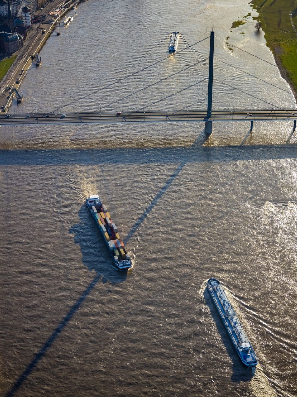Aerial photograph Düsseldorf - Ships and barge trains inland waterway transport in driving on the waterway of the river of Rhein on bridge Oberkasseler Bruecke in the district Oberkassel in Duesseldorf in the state North Rhine-Westphalia, Germany