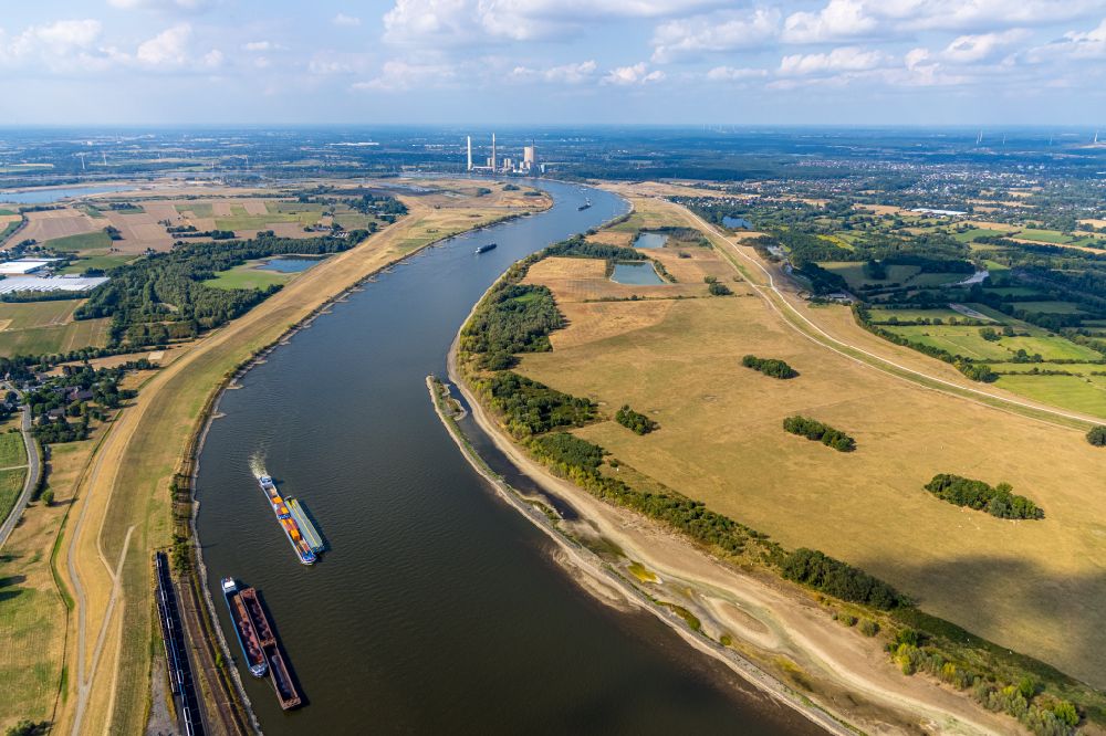 Orsoy from above - Ships and tugboats of inland navigation with reduced loads in the narrowed due to drought and low water level fairway on the waterway on the Rhine river in Orsoy in the state North Rhine-Westphalia, Germany
