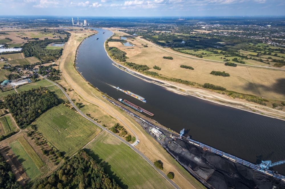 Orsoy from the bird's eye view: Ships and tugboats of inland navigation with reduced loads in the narrowed due to drought and low water level fairway on the waterway on the Rhine river in Orsoy in the state North Rhine-Westphalia, Germany