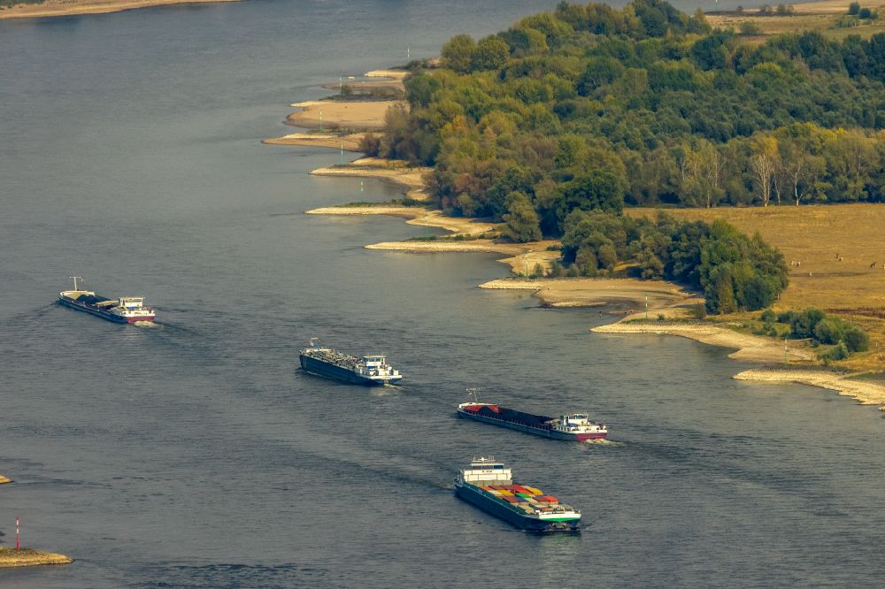 Xanten from above - Ships and tugboats of inland navigation with reduced loads in the narrowed due to drought and low water level fairway on the waterway on the Rhine river in Xanten in the state North Rhine-Westphalia, Germany
