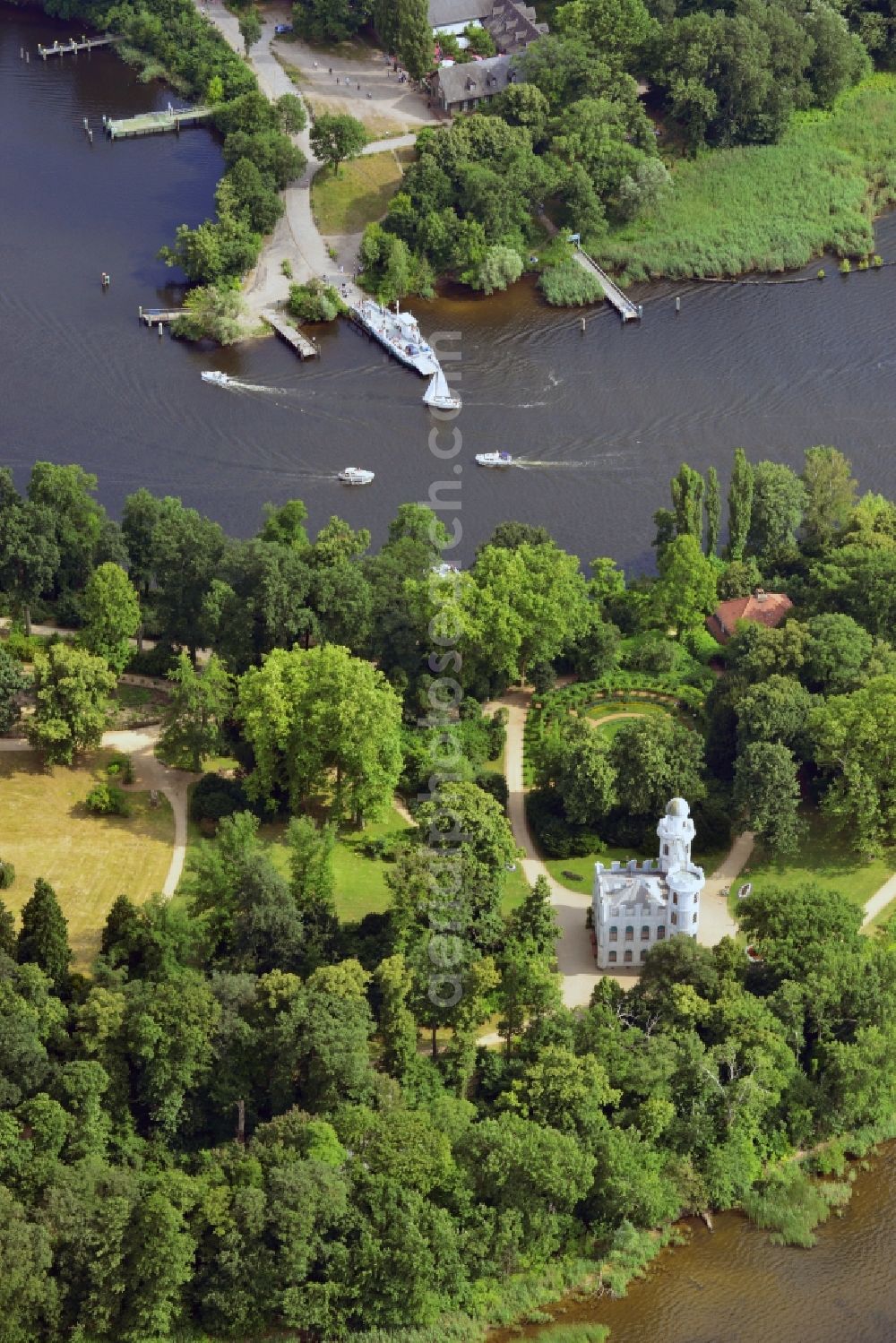 Aerial image Berlin - The Pfaueninsel Palace (peacock island) in the Wannsee part of the district of Steglitz - Zehlendorf in Berlin in the state of Brandenburg. The palace is located on the shore of the river Havel. It was built in the 18th century as a pleasure palace. It was designed in a romantic ruin architecture style and is surrounded by park like landscape on the river. Today it is part of the Potsdam palace and park compound and part of UNESCO world heritage