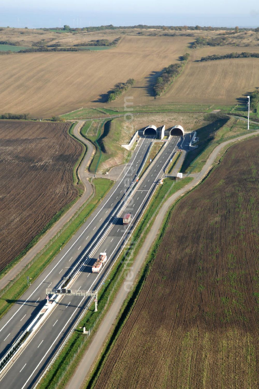Aerial photograph Heldrungen - Blick auf den Schmücketunnel bei Heldrungen in Thüringen. Der Straßentunnel ist ein Teil der Autobahn A71 und unterquert den Höhenzug Schmücke. Gebaut wurde der Tunnel zwischen 2005 und 2009 nach der neuen österreichischen Tunnelbauweise (NÖT).Der Tunnel besteht aus zwei parallelen Röhren mit jeweils zwei Fahrspuren. Die maximale Länge des Tunnels beträgt 1729 Meter. Den Bau des Tunnels übernahm die DEGES. Kontakt DEGES: DEGES, Deutsche Einheit Fernstraßenplanungs- und -bau GmbH, Zimmerstraße 54, 10117 Berlin, Tel. 49(0)30 20243 0, Fax 49(0)30 20243 291, Email: info@deges.de; Kontakt Bauüberwachung: BOL / BÜ Schmücketunnel, Hauptstraße 29, 06577 Oberheldrungen, Tel. 49(0)34673 7823 00, Fax 49(0)34673 7823 99, Email: schmuecketunnel@schuessler-plan.de