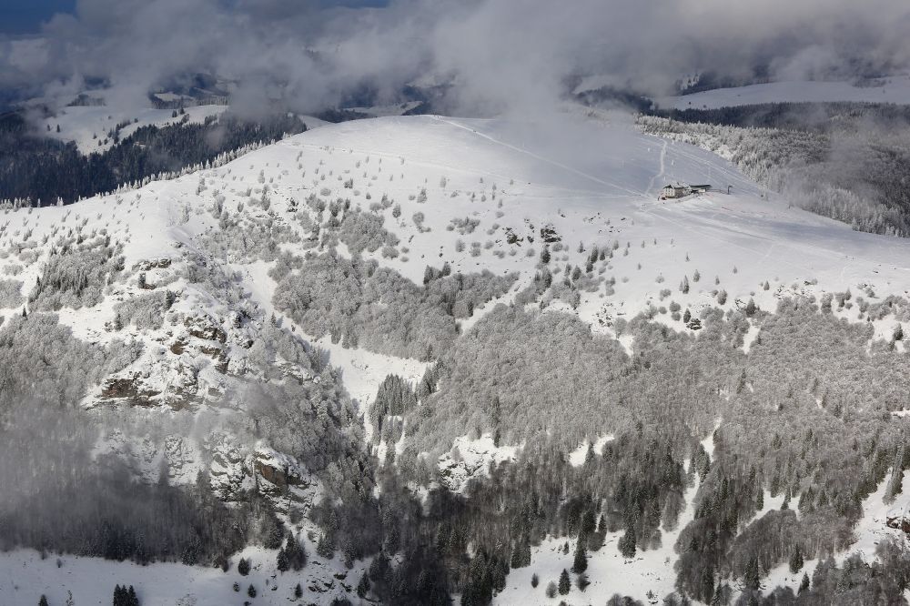 Schönenberg from the bird's eye view: Snow-capped peak region of the Belchen in the Black Forest in Schoenberg in the state of Baden-Wuerttemberg. Mist and clouds envelop the mountain summit in the Black Forest