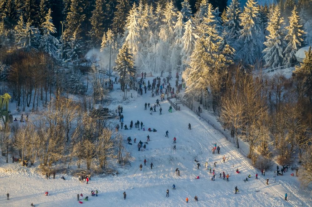 Winterberg from the bird's eye view: Snowy ski slopes and downhill skiing in the winter sports areas in Winterberg in North Rhine-Westphalia