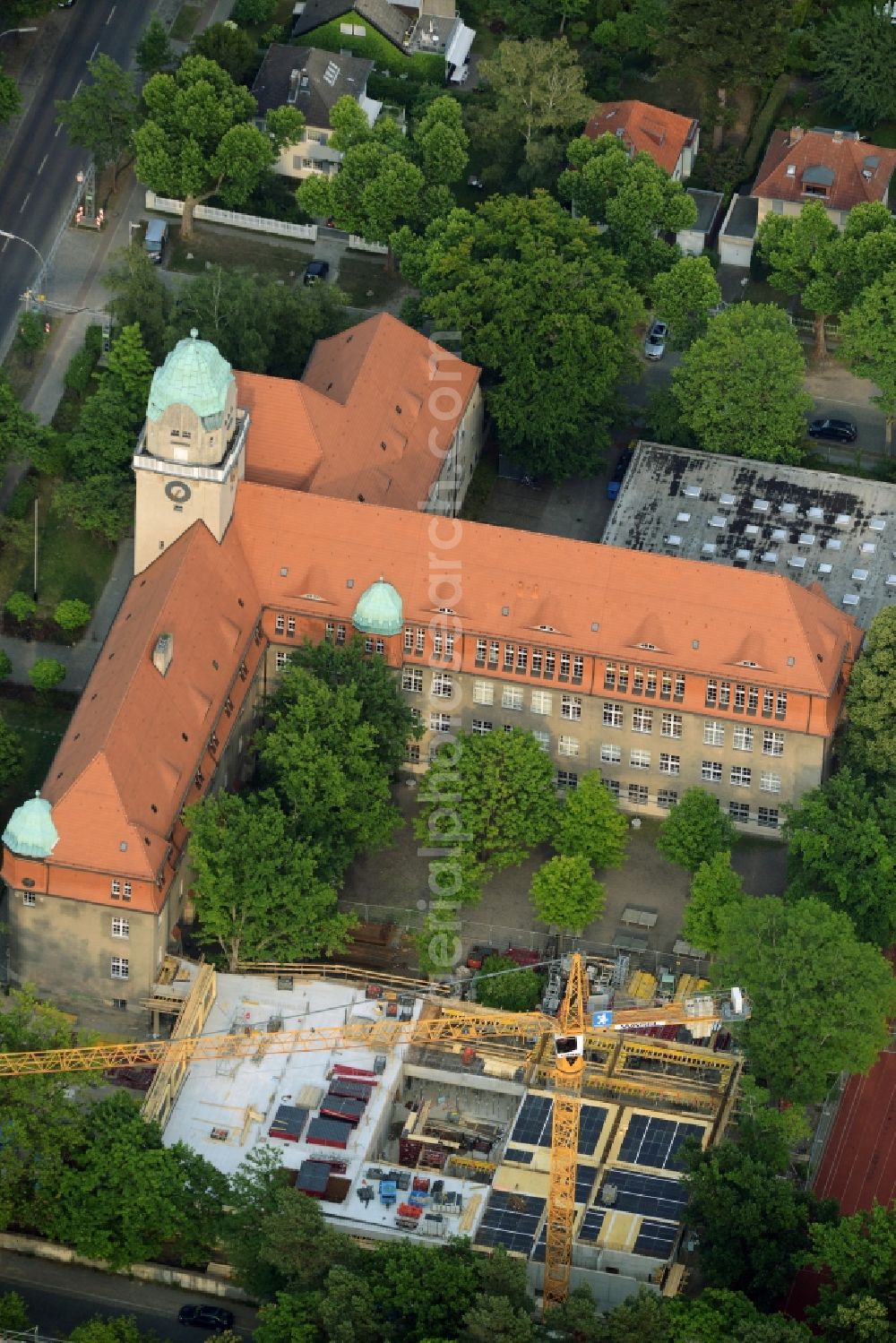 Aerial image Berlin - School grounds, building complex and construction works at Arndt-Gymnasium Dahlem in the district of Steglitz-Zehlendorf in Berlin in Germany. A new building is being developed next to the historic main building with the red roof, small towqer and green dome