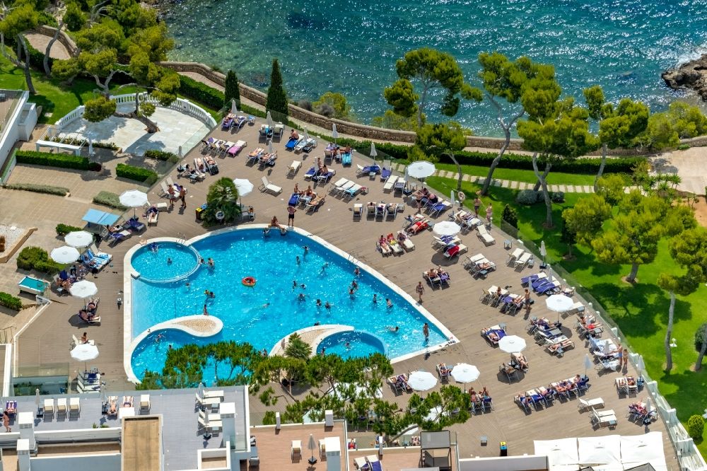 Palmanova from the bird's eye view: Refreshing swim in the blue pool - swimming pool on the roof of the hotel building of the Aparthotel Ponent Mar on Carrer MarquA?s de la Torre in Palmanova in Balearic island of Mallorca, Spain