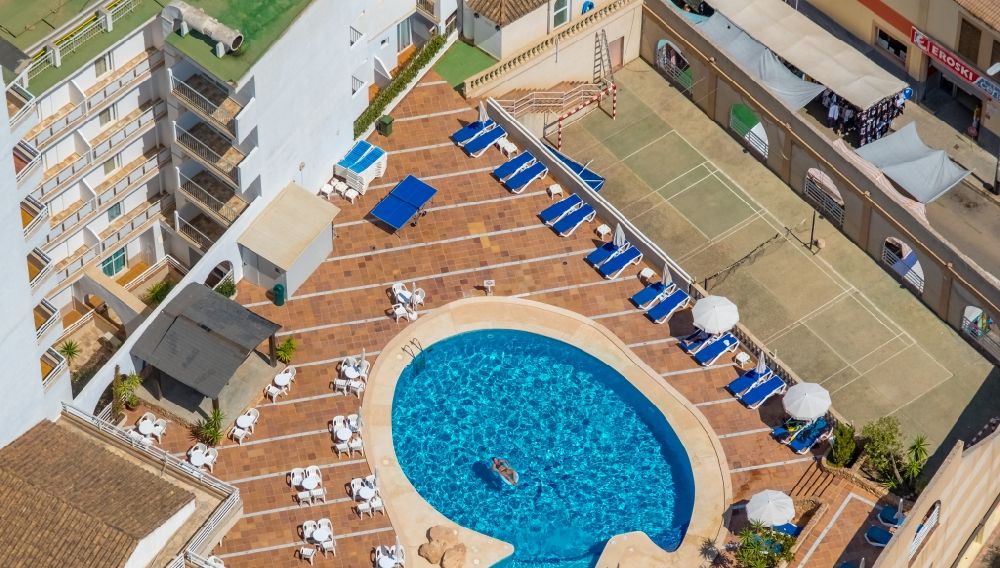 Aerial image Llucmajor - Refreshing swim in the blue pool - swimming pool on the roof of the hotel Hotel Kilimanjaro on Carrer del Gran i General Consell in Llucmajor in Balearic island of Mallorca, Spain