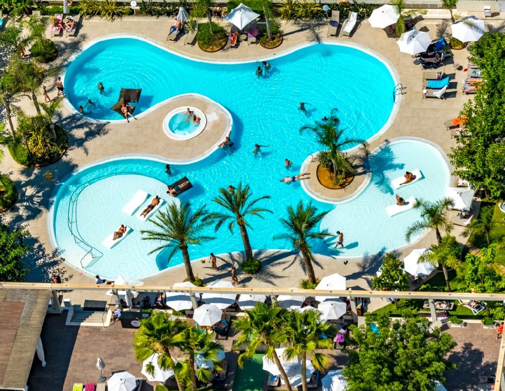 Palma from the bird's eye view: Refreshing swim in the blue pool - swimming pool of Hotel Caballero on Carrer de Neopatria in the district Platja de Palma in Palma in Balearic island of Mallorca, Spain