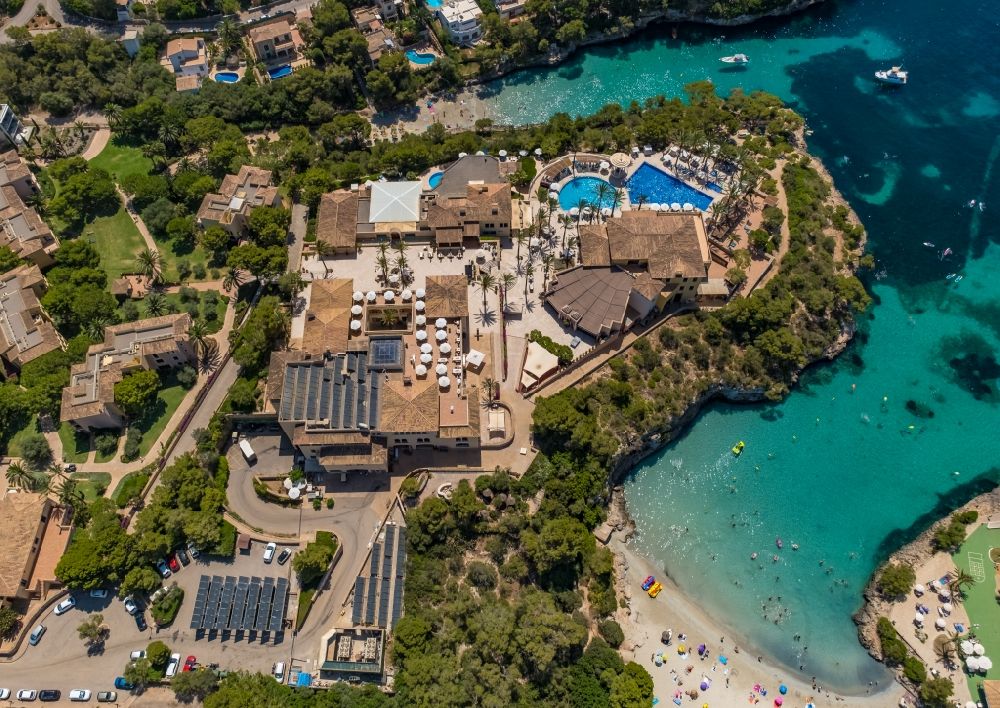 Aerial image Cala D'or - Refreshing swim in the blue pool - swimming pool of Hotel Robinson Cala Serena in Cala D'or in Balearic island of Mallorca, Spain