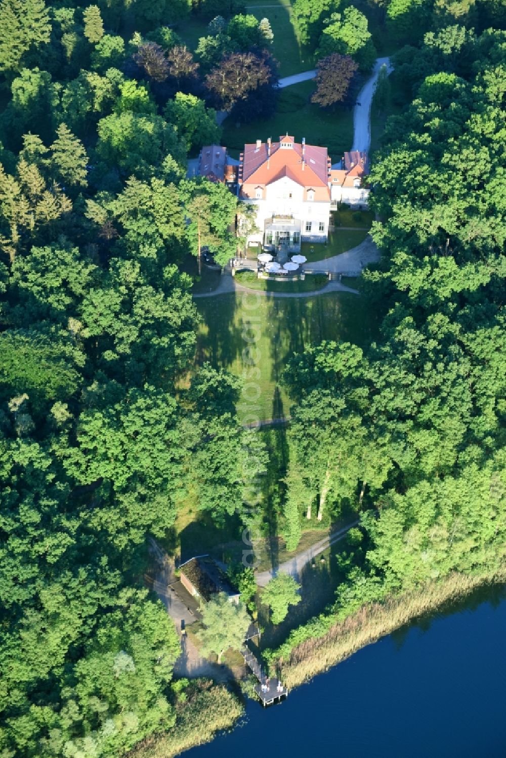 Liebenberg from above - The sea house in the big Lanke lake in the midst of a park with own sea access and footbridge surrounded from a woodland with dear mountain in the Loewenberger country in the federal state Brandenburg