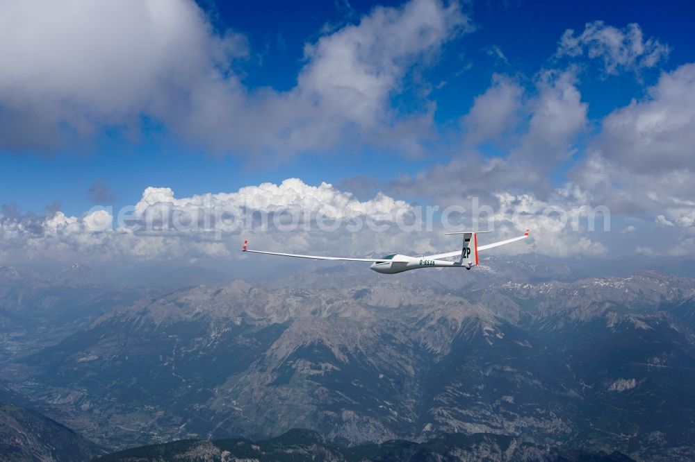 Arvieux from above - Glider ASW 20 D-6538 in flight over the rugged mountain peaks under low-hanging clouds of the mountain Prachaval in the Provence-Alpes-Cote d'Azur, France
