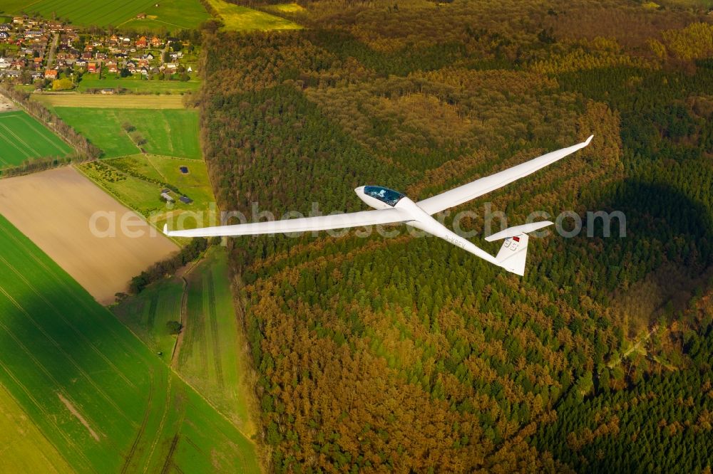 Aerial photograph Deinste - Glider and sport aircraft Duo Discus D-KBFV flying over airspace of Stade in the evening light in Lower Saxony, Germany. This glider is equipped with a small auxiliary engine behind the cockpit in order to be able to reach the home airfield in case of bad thermals