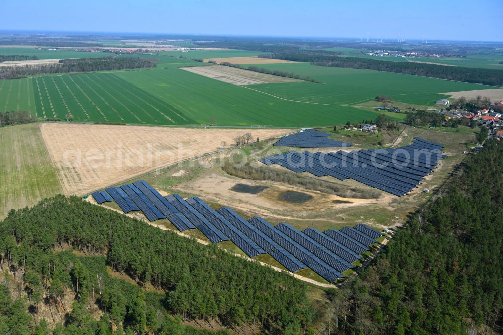Kleinau from above - Rows of panels of a solar power plant and photovoltaic system on a field in Lohne in the state Saxony-Anhalt, Germany