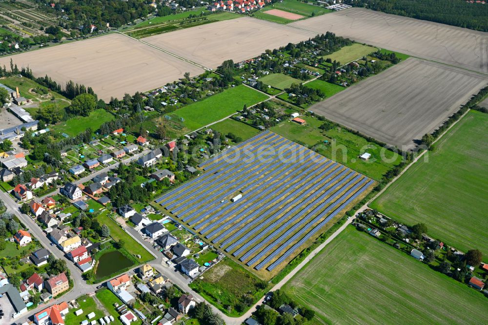Aerial photograph Quesitz - Rows of panels of a solar power plant and photovoltaic system on a field in Quesitz in the state Saxony, Germany