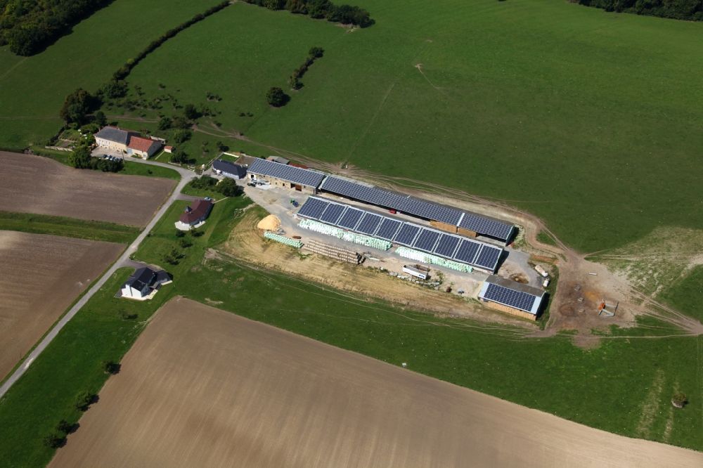 Varize from above - Solar power plant and photovoltaic systems on the roofs of a rural property in Varize in Grand Est, France