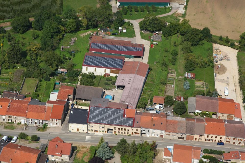 Varize from the bird's eye view: Solar power plant and photovoltaic systems on the roofs of a rural property in Varize in Grand Est, France