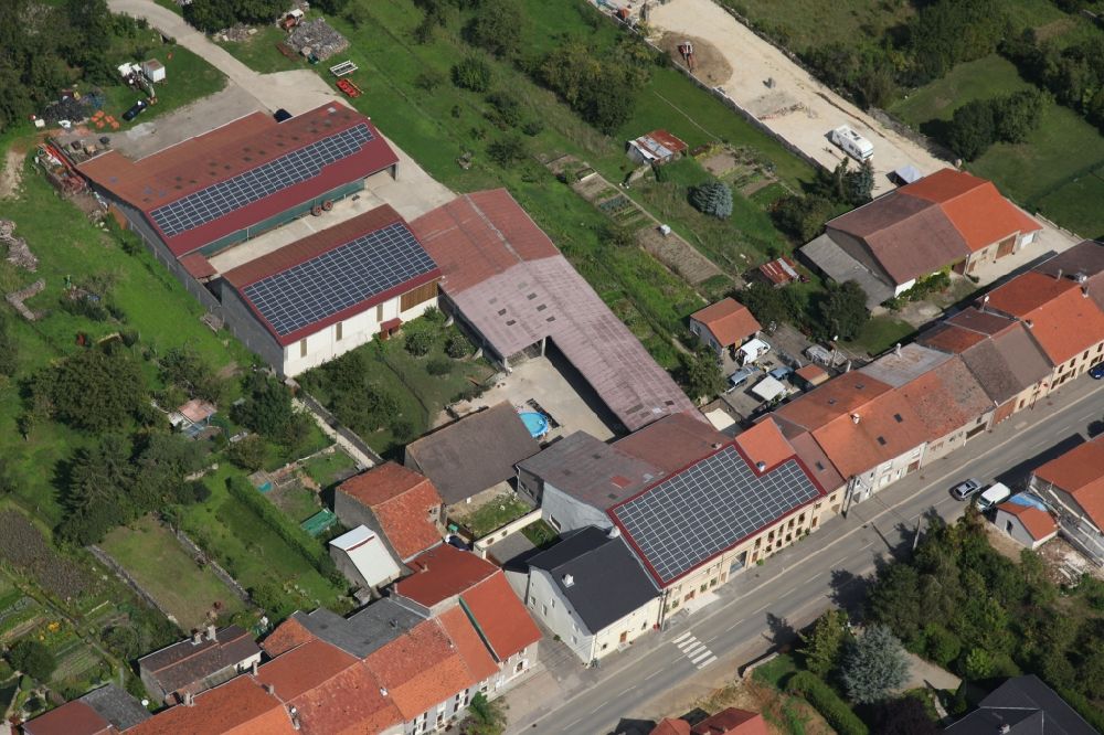 Aerial image Varize - Solar power plant and photovoltaic systems on the roofs of a rural property in Varize in Grand Est, France