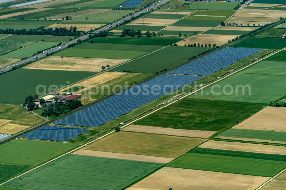 Hohberg from above - Panel rows of photovoltaic and solar farm or solar power plant along the Bahn Rheintal Strecke in Hohberg in the state Baden-Wurttemberg, Germany