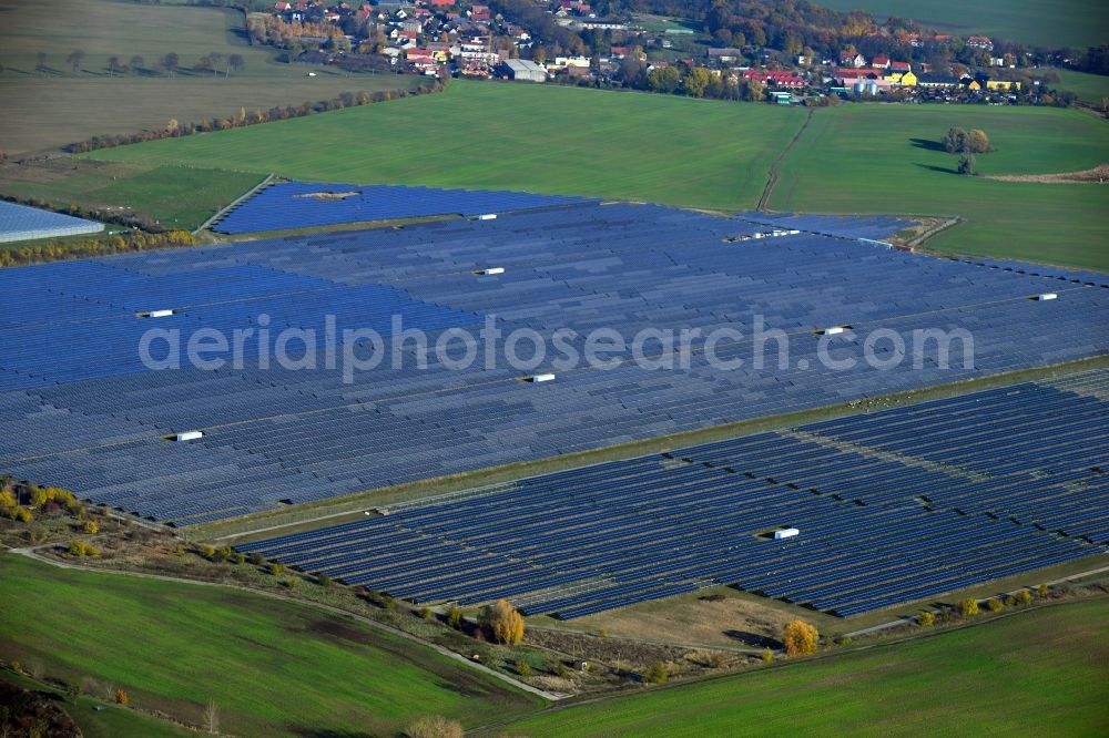 Aerial image Eiche - Panel rows of photovoltaic and solar farm or solar power plant on fields in Eiche in the state Brandenburg, Germany