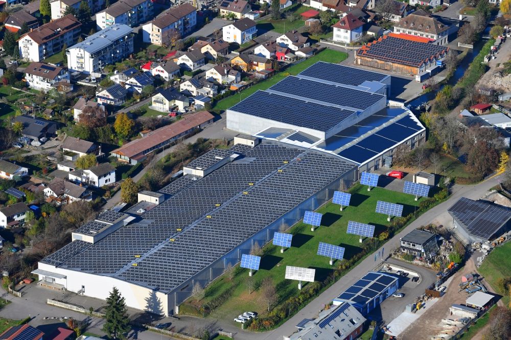 Hausen im Wiesental from the bird's eye view: Panel rows of photovoltaic and solar farm or solar power plant on the company's roof and roof areas of the former textile company Brennet AG in Hausen im Wiesental in the state Baden-Wurttemberg