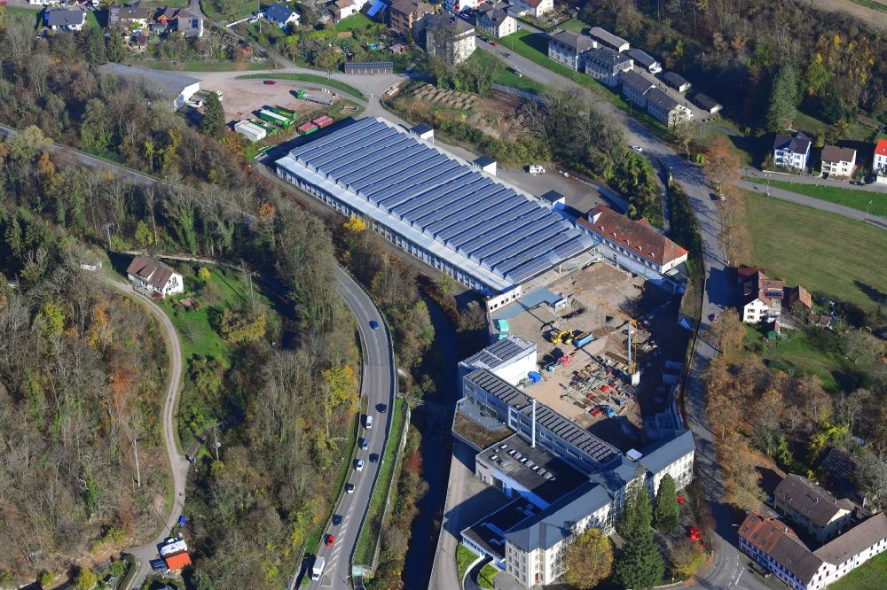 Aerial photograph Wehr - Panel rows of photovoltaic and solar farm on the company's roof of the former textile company Brennet AG, Brennet GmbH and MBB Immobilien in Wehr (Baden) in the state Baden-Wurttemberg. Part of the area is prepared for new residential buildings