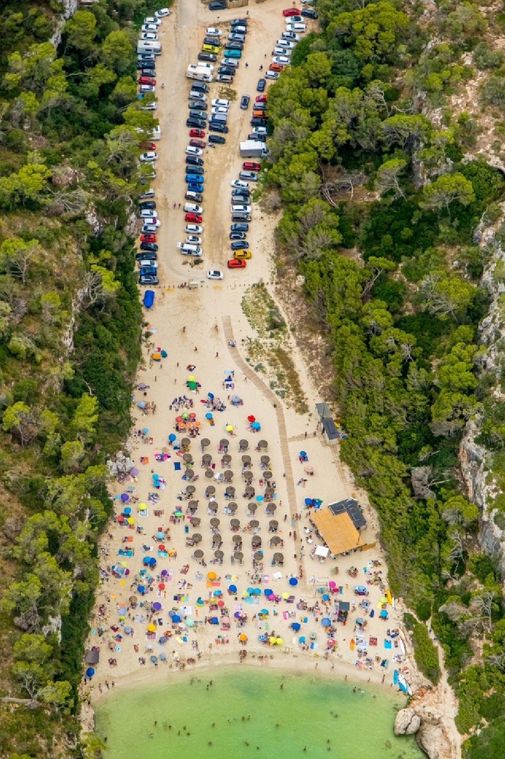 Cala Llombards from the bird's eye view: Row of parasol on the sandy beach ranks in the coastal area Cala Llombards in Cala Llombards in Islas Baleares, Spain