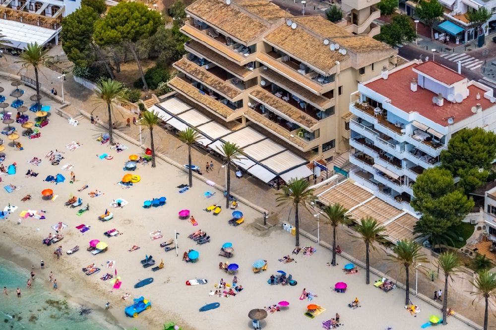 Aerial image Peguera - Parasol - rows on the sandy beach in the coastal area of Platja Palmira along the promenade of the Bulevar de Peguera in Peguera in Balearic island of Mallorca, Spain