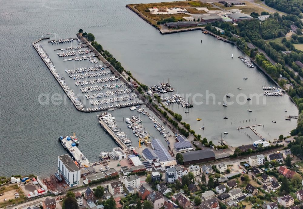 Kiel from the bird's eye view: Pleasure boat moorings and boat moorings on the shore area of the Kieler Foerde in the district Pries in Kiel in the state Schleswig-Holstein, Germany. Moorings in the Stickenhoern sports harbor and boats in the Plueshow Hafen bay and commercial space of the yacht and boat yard Marina Rathje GmbH