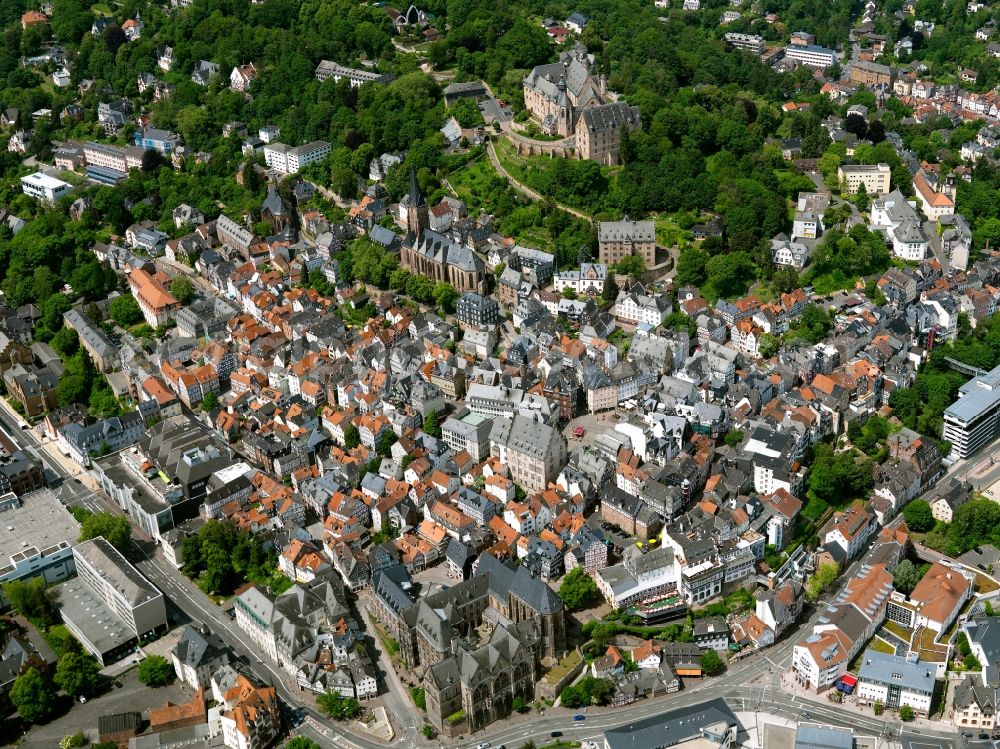 Marburg from above - Cityscape of downtown Marburg in the state of Hesse. View from the river Lahn over the centre of the University city. The Old University building is located in the foreground with the historic buildings and houses of the city centre behind it. The landgrave castle with the castle park is located in the background