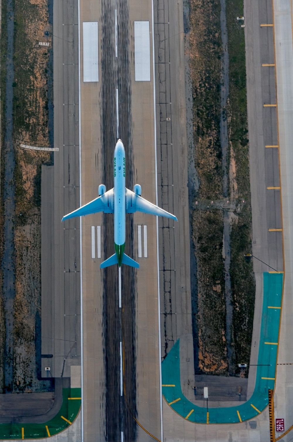 Aerial photograph Los Angeles - Starting passenger jet on a runway of Los Angeles International Airport LAX in sunset in Los Angeles in California, USA