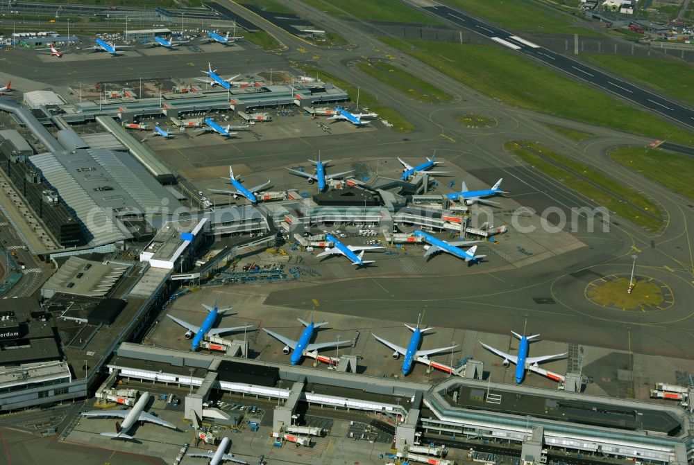 Aerial image Schiphol - Blue passenger aircraft of KLM Royal Dutch Airlines decommissioned at the handling buildings and terminals on the grounds of the airport in Schiphol in Noord-Holland, the Netherlands