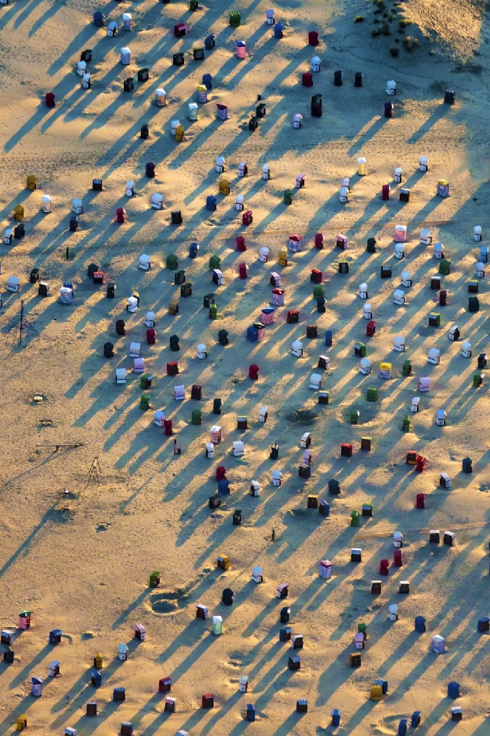 Borkum from the bird's eye view: Beach chair on the sandy beach ranks in the coastal area of the North Sea at the edge of the residential area of Borkum in the state Lower Saxony