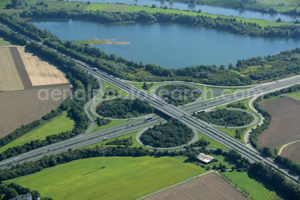 Minden from above - Intersection of the federal highways B61 and B65 on the shore of Lake Baltussee in the South of Minden in the state of North Rhine-Westphalia. The clover-leaf intersection is surrounded by trees and meadows and located on the western shore of the lake