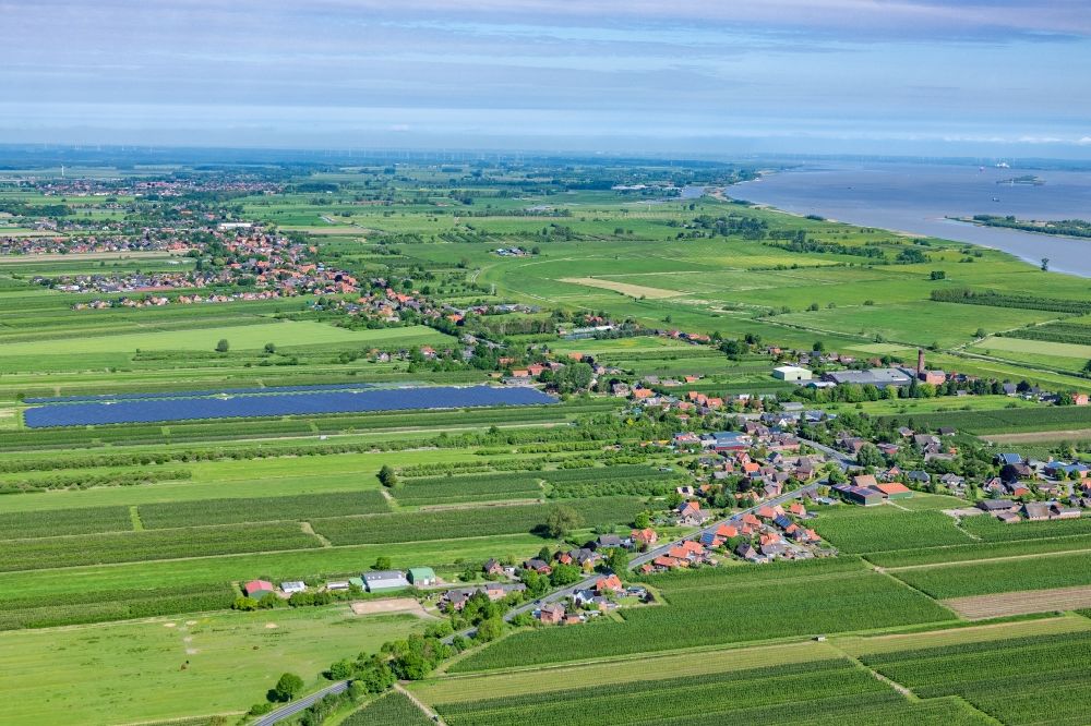 Barnkrug from above - Agricultural land and field boundaries surround the settlement area of the village in Elb Marschland in Barnkrug in the state Lower Saxony, Germany