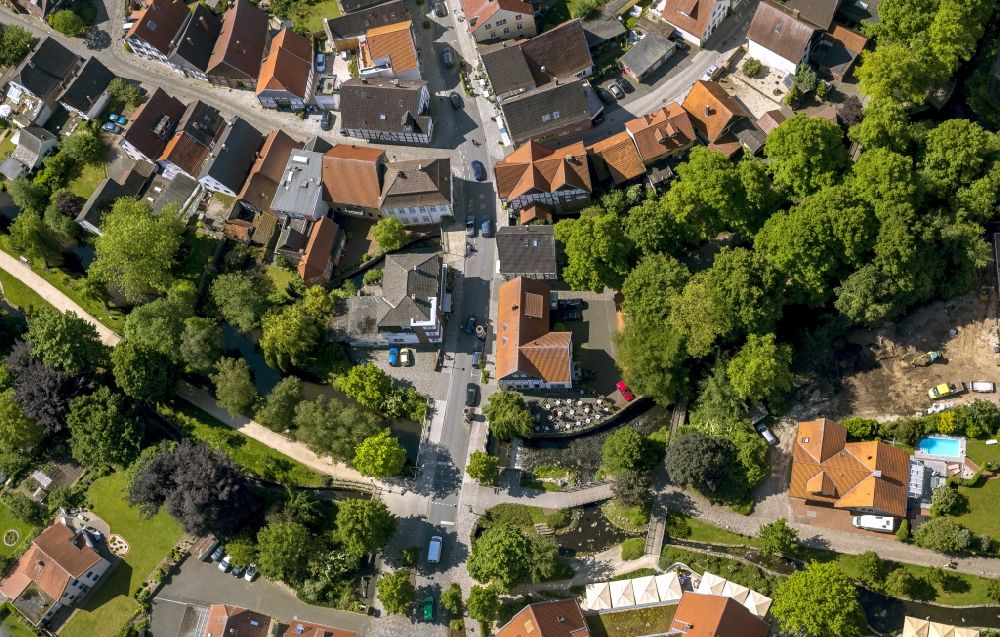 Rietberg from above - View of the course of the Rathausstrasse through a residential area and then over a bridge over the Ems in Rietberg in the state North Rhine-Westphalia. It crosses the path An der Bleiche, which follows the course of the Ems