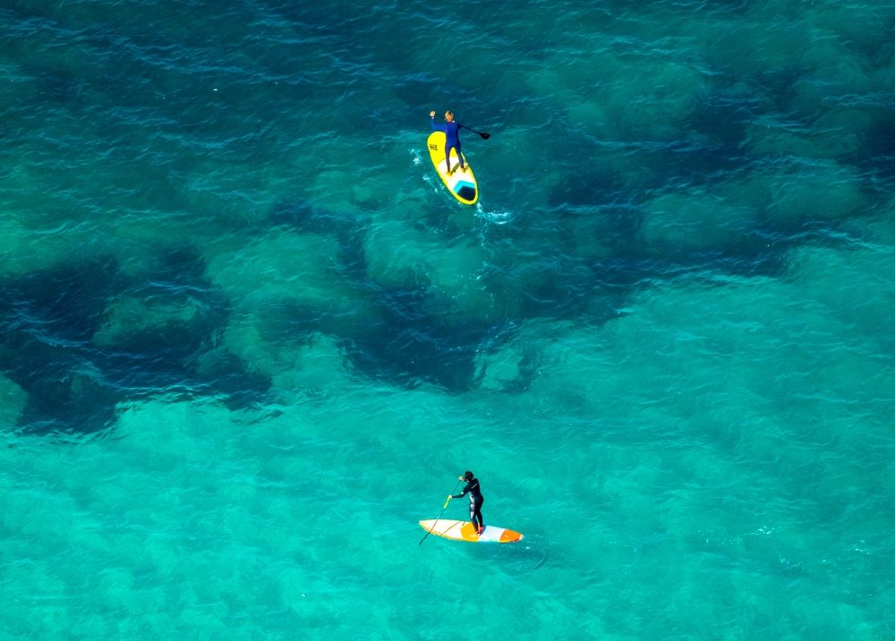 Aerial image Son Real - SUP board sport boat in motion on the water surface in the bay of Alcudia in Son Real in Balearic island of Mallorca, Spain