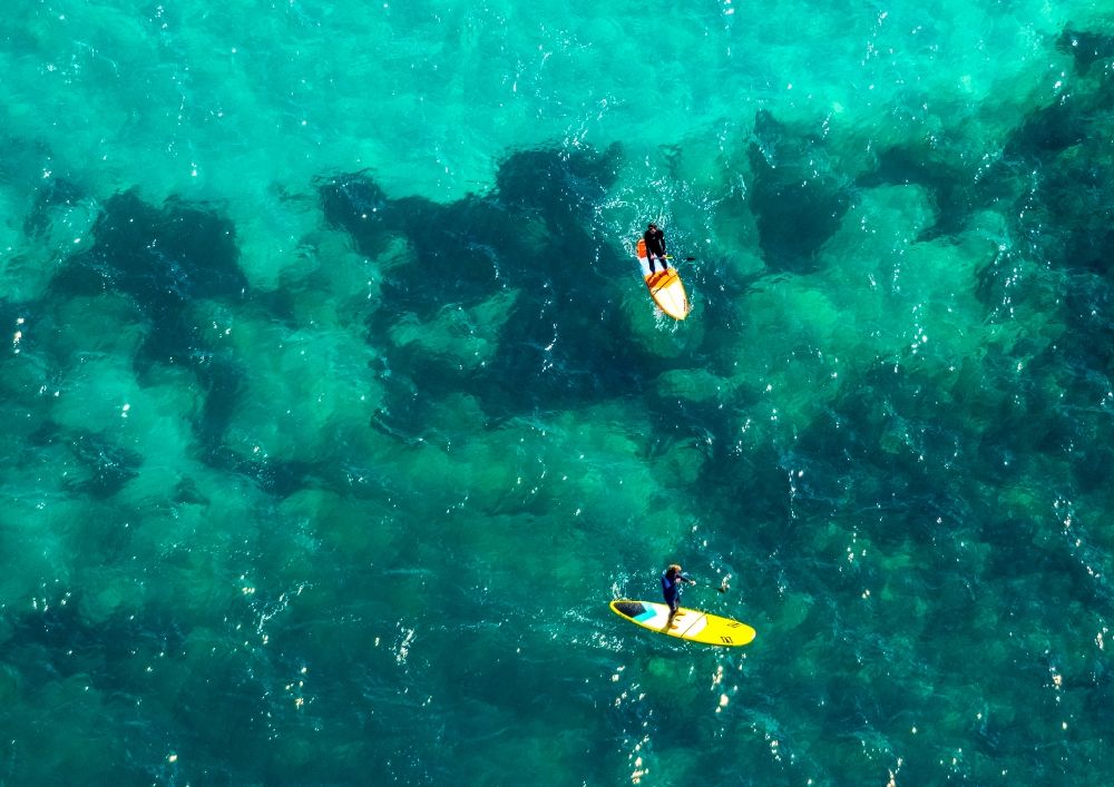 Son Real from above - SUP board sport boat in motion on the water surface in the bay of Alcudia in Son Real in Balearic island of Mallorca, Spain