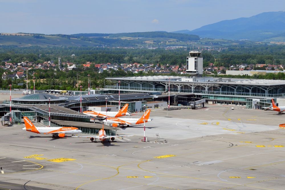 Aerial image Saint-Louis - Terminal area and tarmac on the grounds of the international airport Euroairport in Saint-Louis in Alsace-Champagne-Ardenne-Lorraine, France. Passenger airplanes of the airline Easyjet crisis related groundes in parking Position