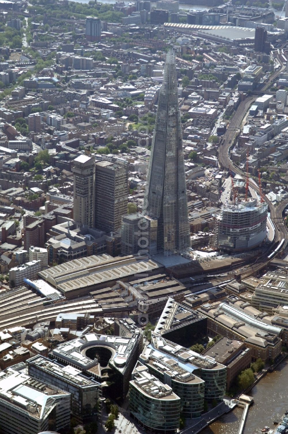 Aerial image London - View The Shard - Europe's tallest building. The high-rise occurs at the London Bridge Station. The Shard London Bridge (formerly known as London Bridge Tower, and Shard of Glass) is a skyscraper under construction in London, which will be on its completion as it stood at 310 meters, the second tallest building in Europe