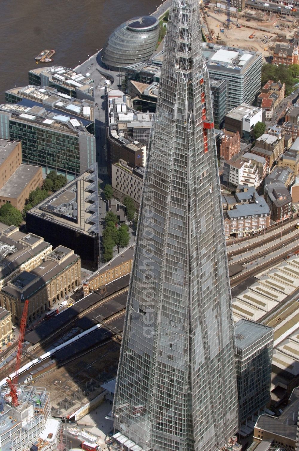 Aerial photograph London - View The Shard - Europe's tallest building. The high-rise occurs at the London Bridge Station. The Shard London Bridge (formerly known as London Bridge Tower, and Shard of Glass) is a skyscraper under construction in London, which will be on its completion as it stood at 310 meters, the second tallest building in Europe