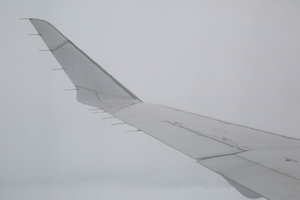 Aerial photograph Singen (Hohentwiel) - The wing of a Bombardier CRJ900 Lufthansa CityLine airliner in flight in the clouds above Singen (Hohentwiel) in the state of Baden- Wuerttemberg