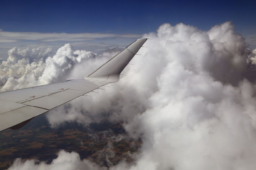 Odelzhausen from the bird's eye view: The wing of an airliner Bombardier CRJ900 of Lufthansa CityLine in flight above the clouds in the area of Odelzhausen in the state of Bavaria