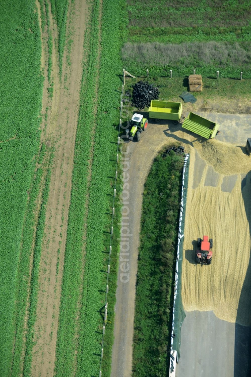Aerial image Zschepplin - Tractors on a farm and agricultural estate on the edge of Zschepplin in the state of Saxony. The compound with its halls and agricultural facilities is located in the North of the borough
