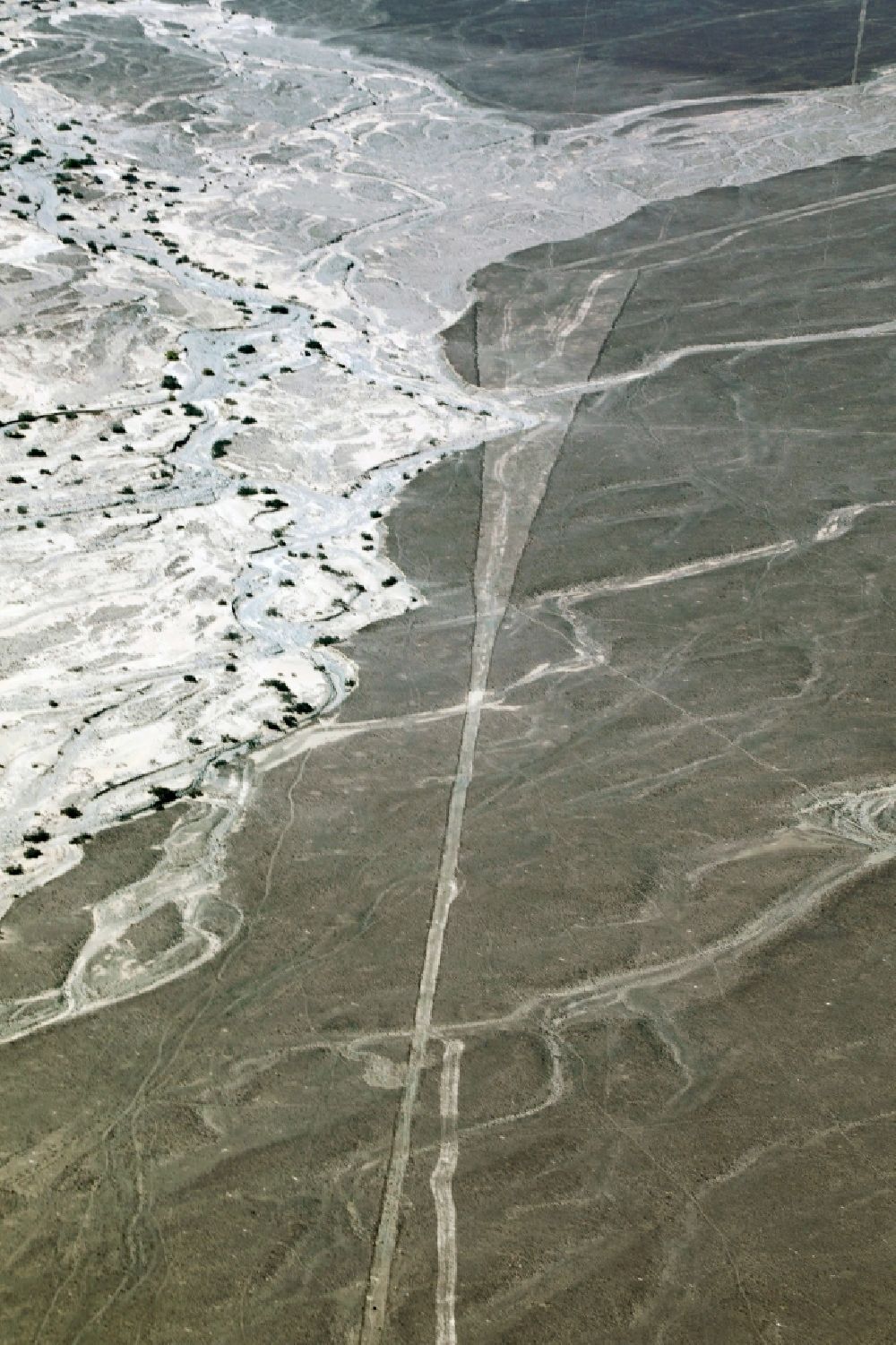 Aerial image Nazca - Landscape of the dry desert deformed by soil erosion and traces of water in Nazca in Ica, Peru