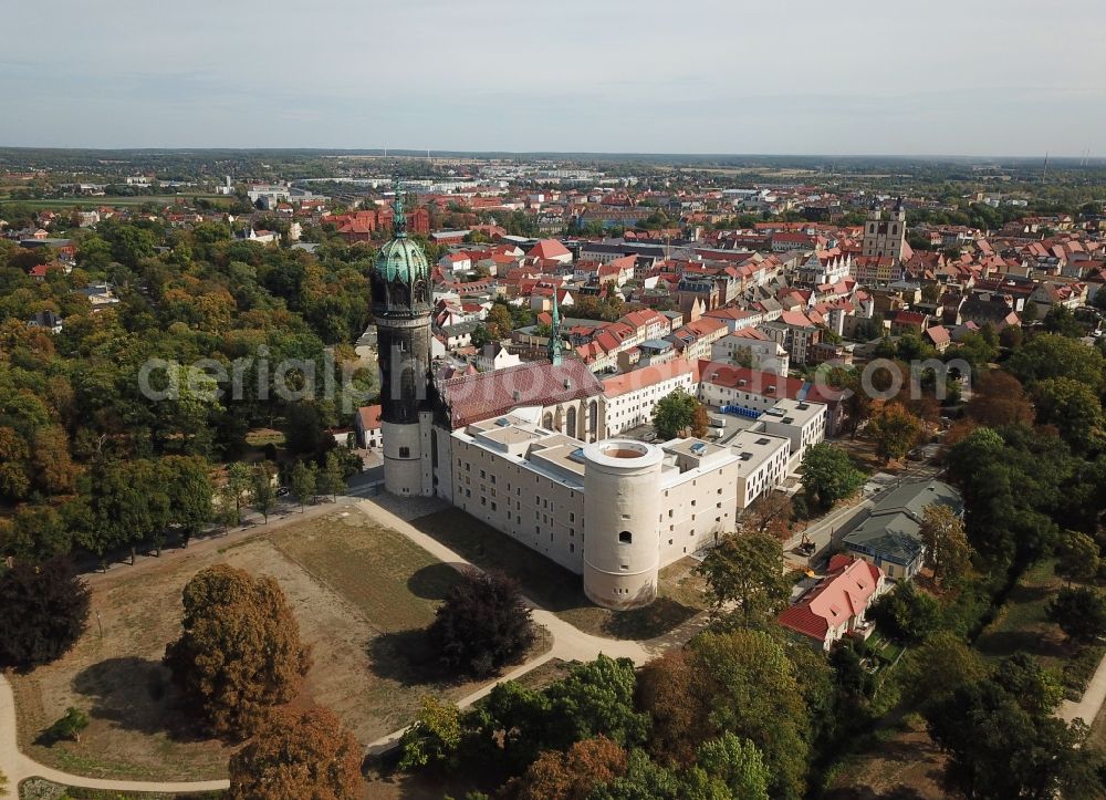 Aerial image Lutherstadt Wittenberg - Castle church of Wittenberg. The castle with high Gothic tower at the west end of the town is a UNESCO World Heritage Site. It gained fame as the Wittenberg Augustinian monk and theology professor Martin Luther spread his disputation